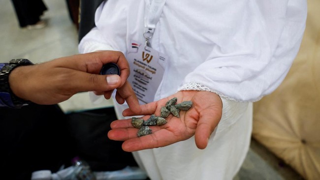 A Muslim pilgrim holds stones in their hand on the first day of the Satan stoning ritual, during the annual hajj pilgrimage, in Mina, Saudi Arabia, May 27, 2026. REUTERS/Ibraheem Abu Mustafa