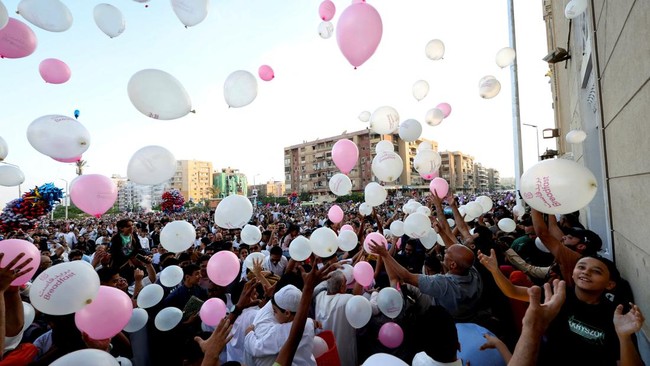 People attempt to catch balloons released after an Eid al-Adha prayer at a public park, outside El-Seddik Mosque in Cairo, Egypt, May 27, 2026. REUTERS/Mohamed Abd El Ghany