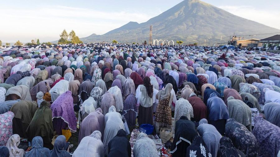 Para wanita Muslim Indonesia melaksanakan salat berjamaah Iduladha di lapangan terbuka dengan latar belakang Gunung Sindoro, di desa Butuh, Wonosobo, provinsi Jawa Tengah, Rabu (27/5/2026). (REUTERS/Dwi Oblo)