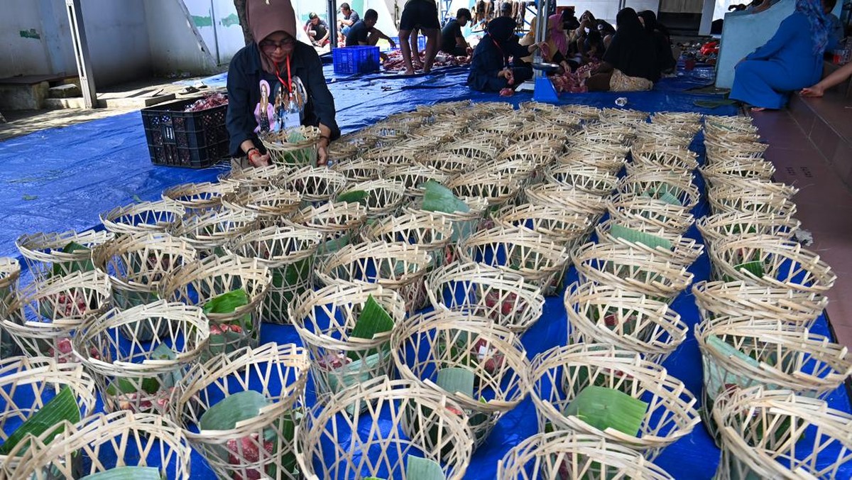 Panitia mengemas daging kurban ke dalam keranjang bambu sebelum disalurkan kepada dhuafa di lingkungan permukiman kawasan Ciracas, Jakarta, Rabu (27/5/2026). Dinas Lingkungan Hidup (DLH) DKI Jakarta mengajak masyarakat menerapkan konsep EcoQurban saa