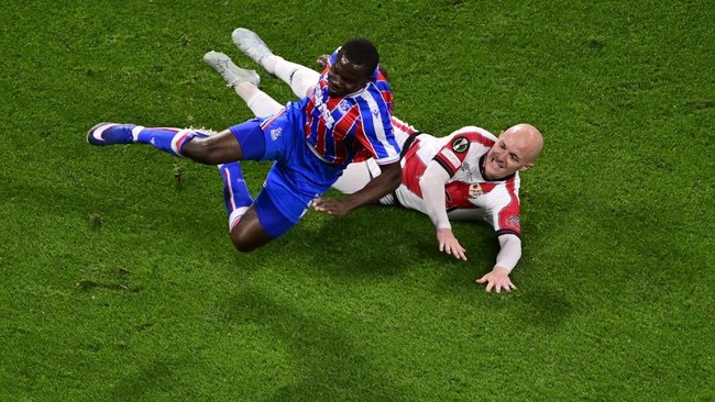 Rayo Vallecano's Spanish forward #07 Isi Palazon (Back) fouls Crystal Palace's English defender #03 Tyrick Mitchell (Front) during the UEFA Conference League final football match between Crystal Palace FC and Rayo Vallecano de Madrid in Leipzig, Germ