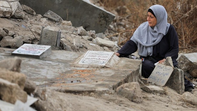 A Palestinian woman reacts as she visits a grave at a cemetery on Eid al-Adha, in Gaza City, May 27, 2026. REUTERS/Dawoud Abu Alkas