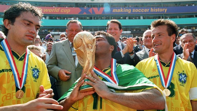 Romario (tengah) mencium trofi Piala Dunia pada 1994 sembari dilihat Branco (kiri) dan Dunga. (AFP/TIMOTHY A. CLARY)