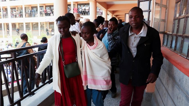 A parent walks with a student at the Utumishi Girls' Academy Senior School following an overnight fire a dormitory in Gilgil, Nakuru county, Kenya May 28, 2026. REUTERS/Monicah Mwangi