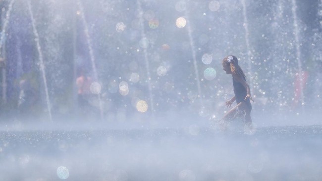A girl walks in a fountain to cool off on a hot day, as temperatures hit 30 degrees Celsius (86 degrees Fahrenheit), in Moscow, Russia, May 22, 2026. REUTERS/Ramil Sitdikov
