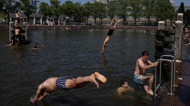 People swim during an unseasonably hot day at the Marineterrein in Amsterdam, Netherlands, May 26, 2026. REUTERS/Stelios Misinas