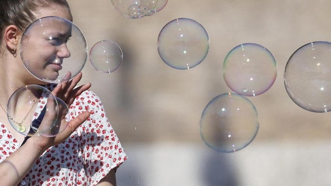 A woman reacts to soap bubbles in Piazza del Popolo, in Rome, Italy, May 27, 2026. REUTERS/Yara Nardi