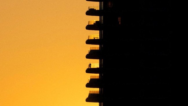 A person on a balcony of a building during sunset in Nicosia, Cyprus May 21, 2026. REUTERS/Yiannis Kourtoglou