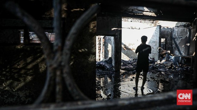 Sejumlah warga mengevakuasi barang dari rumah yang hangus terbakar di Krendang, Jakarta Barat, Jumat (29/5/2026). (CNN Indonesia/Febria Adha L)