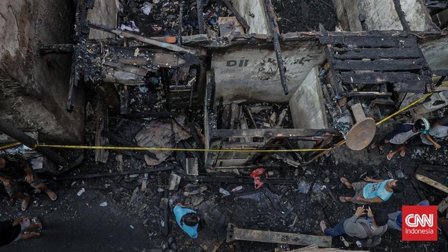Sejumlah warga mengevakuasi barang dari rumah yang hangus terbakar di Krendang, Jakarta Barat, Jumat (29/5/2026). (CNN Indonesia/Febria Adha L)