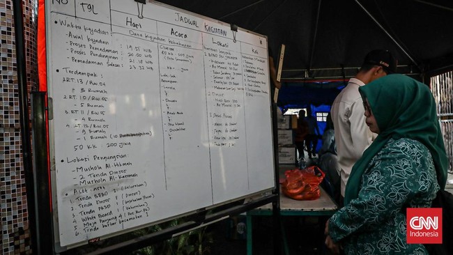 Sejumlah warga mengevakuasi barang dari rumah yang hangus terbakar di Krendang, Jakarta Barat, Jumat (29/5/2026). (CNN Indonesia/Febria Adha L)