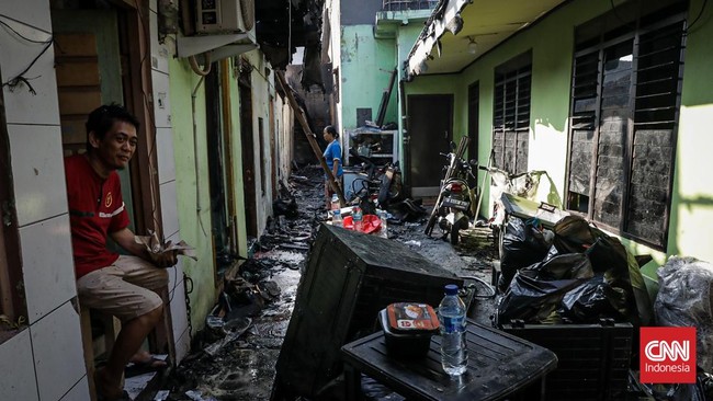 Sejumlah warga mengevakuasi barang dari rumah yang hangus terbakar di Krendang, Jakarta Barat, Jumat (29/5/2026). (CNN Indonesia/Febria Adha L)