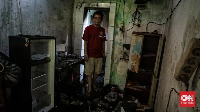 Sejumlah warga mengevakuasi barang dari rumah yang hangus terbakar di Krendang, Jakarta Barat, Jumat (29/5/2026). (CNN Indonesia/Febria Adha L)