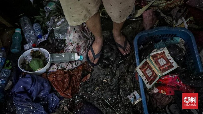 Sejumlah warga mengevakuasi barang dari rumah yang hangus terbakar di Krendang, Jakarta Barat, Jumat (29/5/2026). (CNN Indonesia/Febria Adha L)