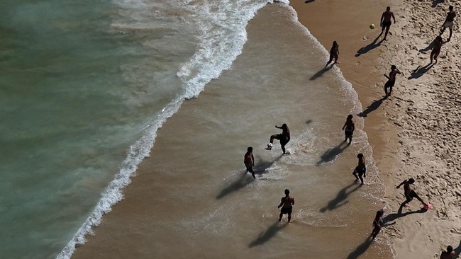 Youths play altinha, a Brazilian game where players gather to keep a ball in the air without using their hands, at Ipanema beach in Rio de Janeiro, Brazil April 16, 2026. REUTERS/Pilar Olivares