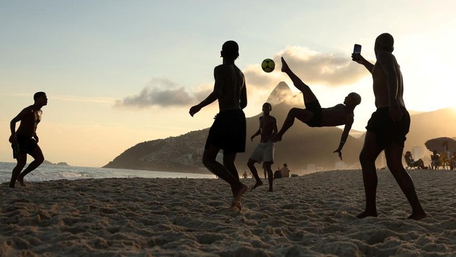 Youths play altinha, a Brazilian game where players gather to keep a ball in the air without using their hands, at Ipanema beach in Rio de Janeiro, Brazil April 16, 2026. REUTERS/Pilar Olivares