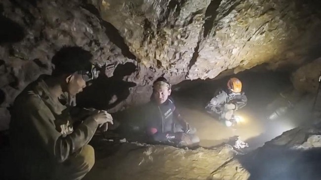 This screengrab made from handout video footage taken on May 29, 2026, and provided by Benz Norrased Palasing of Seascout Diving, shows a rescue team (C, R) about to free one (L) of seven men trapped in a semi-submerged cave in central Xaysomboun pro