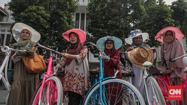 Sejumlah wisatawan membawa payung saat mengunjungi Kota Tua, Jakarta Barat, Sabtu (30/5/2025) siang.