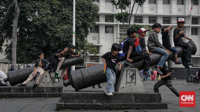 Sejumlah wisatawan membawa payung saat mengunjungi Kota Tua, Jakarta Barat, Sabtu (30/5/2025) siang.