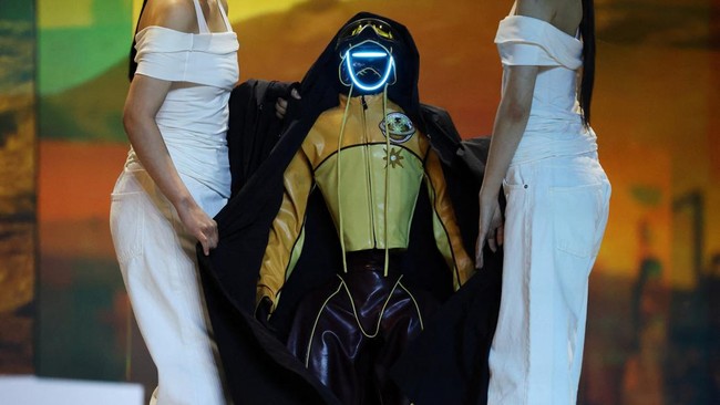 Robot dan model berjalan di atas catwalk dengan mengenakan busana serasi di Seoul.