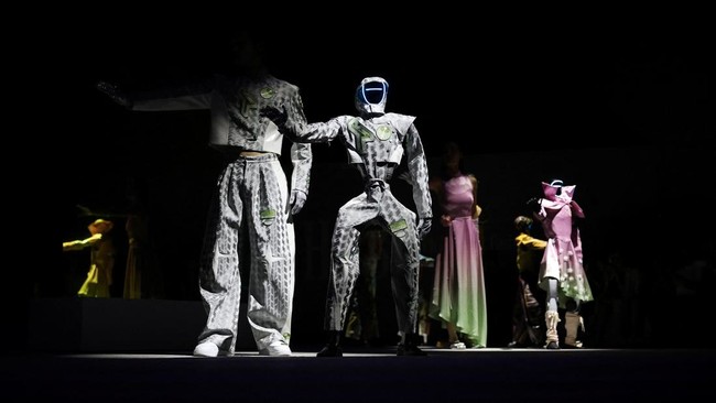 Robot dan model berjalan di atas catwalk dengan mengenakan busana serasi di Seoul.