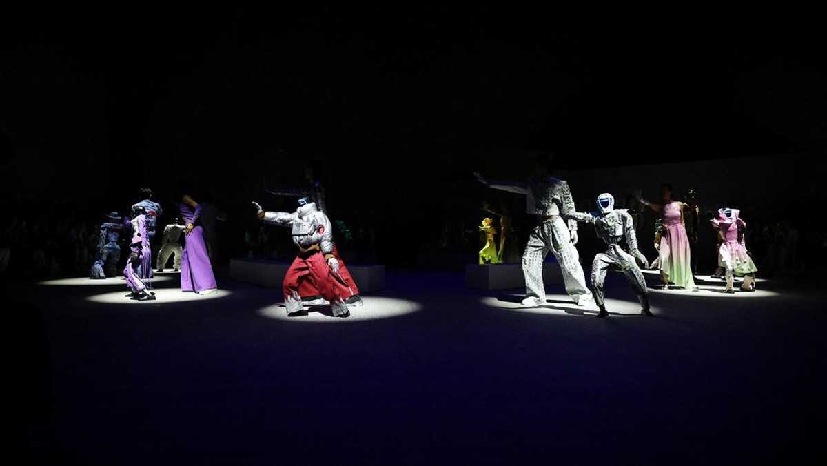 Robot dan model berjalan di atas catwalk dengan mengenakan busana serasi di Seoul.