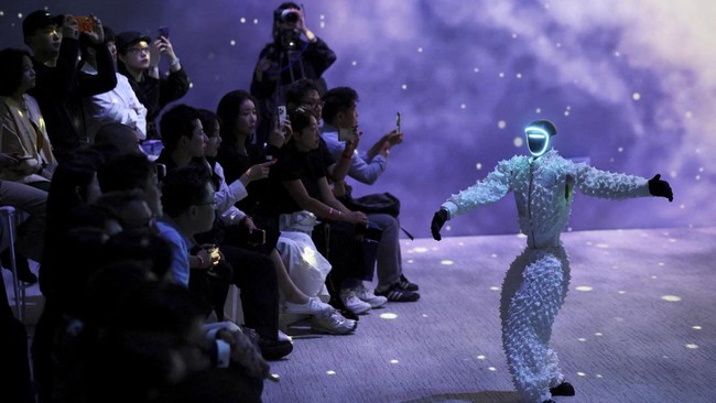 Robot dan model berjalan di atas catwalk dengan mengenakan busana serasi di Seoul.