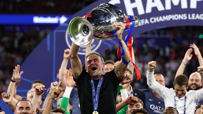 Paris Saint-Germain's Spanish head coach Luis Enrique (C) lifts the trophy as he celebrates with his players after winning the UEFA Champions League final football match between Paris Saint-Germain (PSG) and Arsenal FC at the Puskas Arena in Budapest