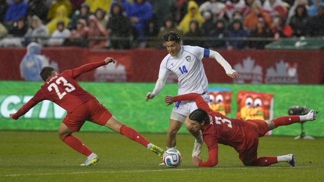 EDMONTON, ALBERTA - JUNE 01: Eldor Shomurodov of Uzbekistan competes for the ball with Alfie Jones and Niko Sigur of Canada during the international friendly match between Canada and Uzbekistan at Commonwealth Stadium on June 01, 2026 in Edmonton, Al
