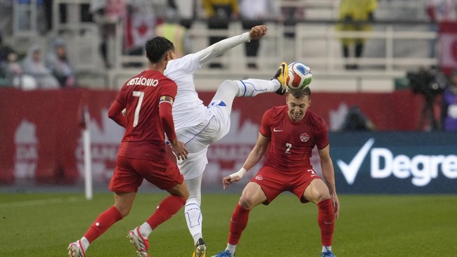 EDMONTON, ALBERTA - JUNE 01: Alistair Johnston of Canada competes for the ball with Otabek Shukurov of Uzbekistan during the international friendly match between Canada and Uzbekistan at Commonwealth Stadium on June 01, 2026 in Edmonton, Alberta.   J