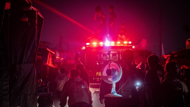 Warga membawa perabotan rumah saat terjadi kebarakan di Jalan Kemayoran Gempol, Kebon Kosong, Kemayoran, Jakarta, Senin (1/6/2026). Sebanyak 33 unit mobil pemadam kebakaran beserta 100 personel dikerahkan untuk menangani kebakaran yang melanda permuk