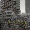 Rescuers work at a residential building partially destroyed following Russian drone and missile strikes in Kyiv on May 14, 2026, amid the Russian invasion in Ukraine. Ukraine's capital came under heavy aerial attack early on May 14, an AFP journalist