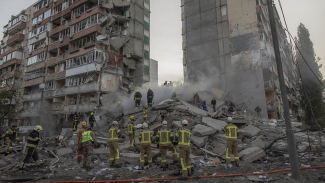 Rescuers work at a residential building partially destroyed following Russian drone and missile strikes in Kyiv on May 14, 2026, amid the Russian invasion in Ukraine. Ukraine's capital came under heavy aerial attack early on May 14, an AFP journalist