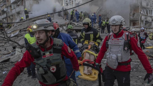 Rescuers carry an injured person at the site of a residential building that was partially destroyed following Russian drones and missiles strikes in Kyiv on May 14, 2026, amid the Russian invasion in Ukraine. Ukraine's capital came under heavy aerial