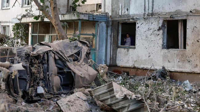 A woman inspects a building damaged during Russian missile and drone strikes, amid Russia's attack on Ukraine, in Kyiv, Ukraine June 2, 2026. REUTERS/Valentyn Ogirenko