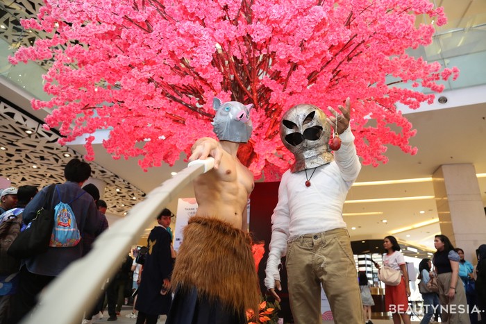 Cosplayer kiri mengikuti gaya Hashibira Inosuke dari anime Demon Slayer: Kimetsu no Yaiba yang memakai topeng babi hutan khasnya tanpa baju atas. Sementara, cosplayer kanan adalah Griffith dari serial legendaris Berserk.