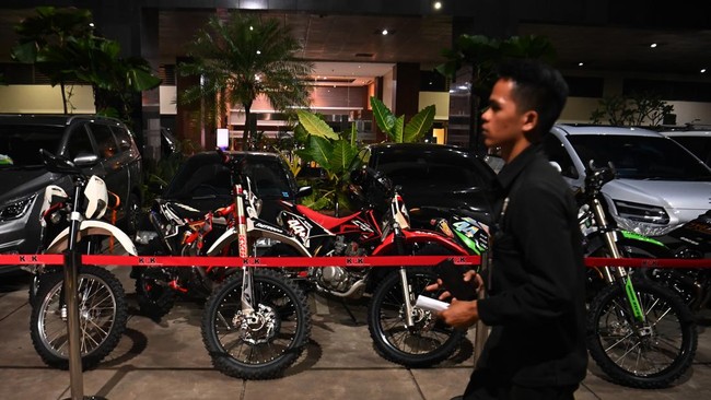 Petugas melintas di depan kendaraan barang bukti kasus OTT di lingkungan Direktorat Jenderal Imigrasi saat tiba di Gedung Merah Putih KPK, Jakarta, Rabu (3/6/2026). KPK menyita 33 kendaraan yang terdiri dari tujuh mobil, 15 motor dan 11 sepeda terkai