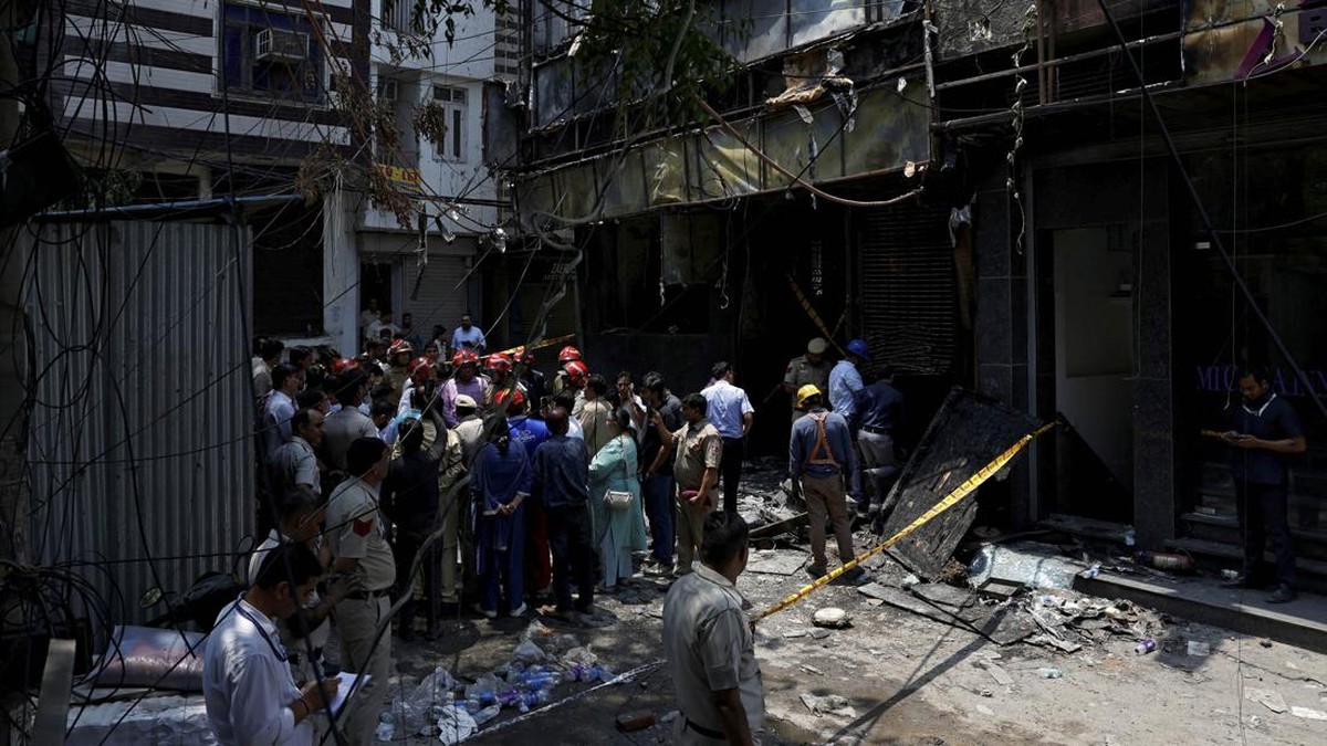 Firefighters and police officers stand at the site after a fire at a hotel in New Delhi, India, June 3, 2026. REUTERS/Adnan Abidi