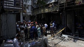 Firefighters and police officers stand at the site after a fire at a hotel in New Delhi, India, June 3, 2026. REUTERS/Adnan Abidi