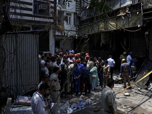 Firefighters and police officers stand at the site after a fire at a hotel in New Delhi, India, June 3, 2026. REUTERS/Adnan Abidi
