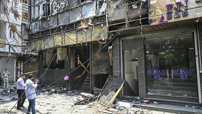 Forensics team members take photographs of the site following a fire that broke out at a hotel in New Delhi on June 3, 2026. At least 21 people were killed when a fire ripped through a hotel in New Delhi on June 3, police said, in one of the deadlies