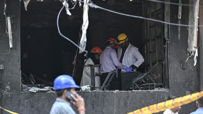 Forensics team members inspect the site following a fire that broke out at a hotel in New Delhi on June 3, 2026. At least 21 people were killed when a fire ripped through a hotel in New Delhi on June 3, police said, in one of the deadliest blazes in