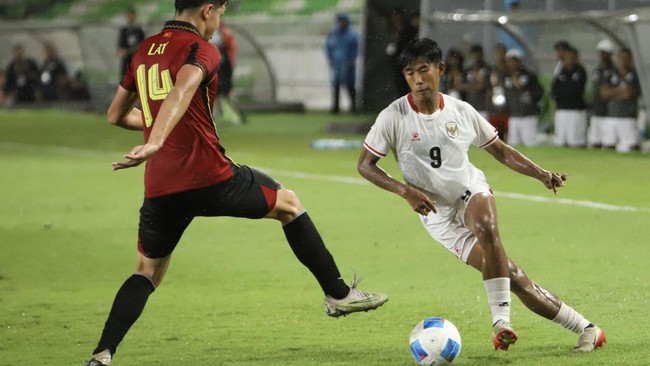 Pesepak bola Timnas Indonesia U-19 Dimas Adi Prasetyo (kanan) berebut bola dengan pesepak bola Timnas Timor Leste U-19 Tiago William Torres Lay (kiri) pada pertandingan Piala AFF U-19 2026 di Stadion Utama Sumatera Utara, Kabupaten Deli Serdang, Suma