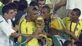 Brazil's forward Ronaldo (C) and midfielder Gilberto Silva (2nd R) kiss the World Cup trophy, during the award ceremony 30 June, 2002 at the International Stadium Yokohama, Japan, after Brazil won 2-0 against Germany in match 64 of the 2002 FIFA Worl