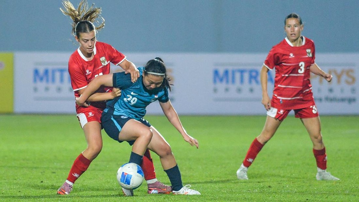 Pesepak bola timnas putri Indonesia Isabelle Nottet (kiri) berebut bola dengan pesepak bola timnas putri Singapura Ee Pei Ying (tengah) saat bertanding pada ajang Garuda Championship Series di Stadion Arcamanik, Bandung, Jawa Barat, Rabu (3/6/2026).