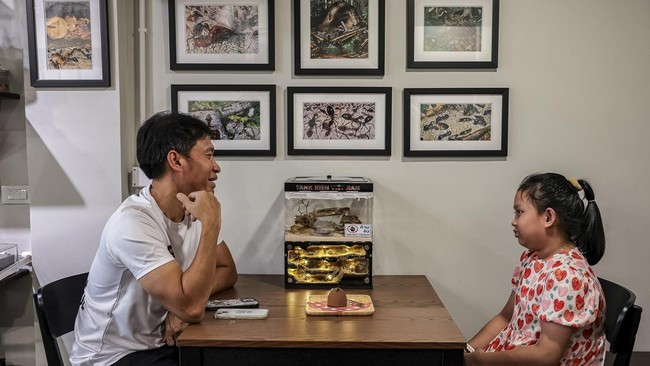 A man and his daugther sit as they observe ant colonies at the Ant Keeping cafe in Bangkok, Thailand, May 29, 2026. REUTERS/Chalinee Thirasupa.