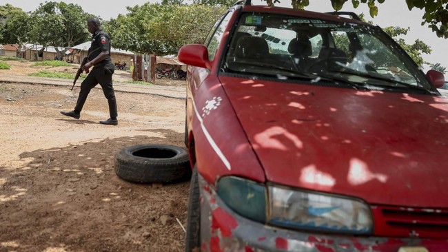 A Nigerian policeman walks past an attacked car in the Yawota community, where dozens of pupils and teachers were abducted in a large-scale school attack, in Oyo State, Nigeria, June 2, 2026. REUTERS/Sodiq Adelakun