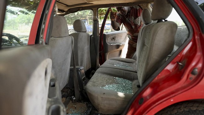 A witness to the abduction of dozens of students and teachers points at shattered glass in his car, damaged by gunfire, in Oyo State, Nigeria, June 2, 2026. REUTERS/Sodiq Adelakun