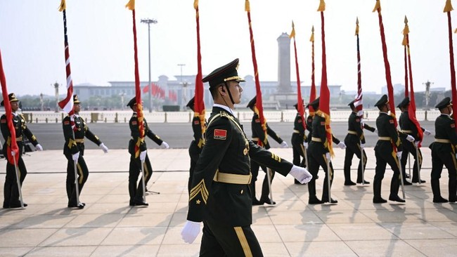 Chinese People's Liberation Army (PLA) honour guard march in front of the Great Hall of the People ahead of a welcome ceremony for US President Donald Trump in Beijing on May 14, 2026. (Photo by Brendan SMIALOWSKI / AFP)