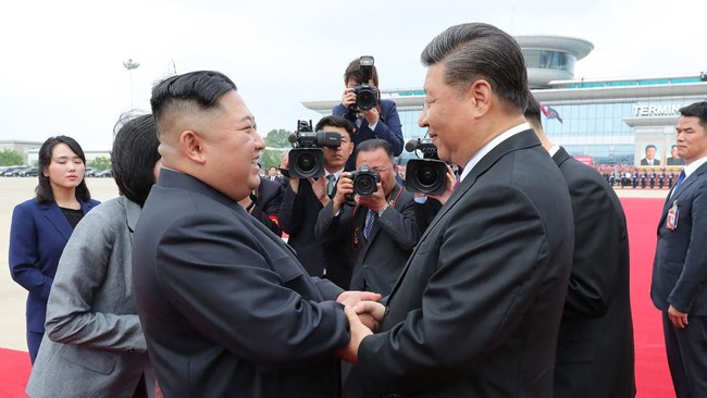 (FILES) This June 21, 2019 picture released from North Korea's official Korean Central News Agency (KCNA) on June 22, 2019 shows China's President Xi Jinping (centre R) speaking with North Korean leader Kim Jong Un (front L) upon his departure at the
